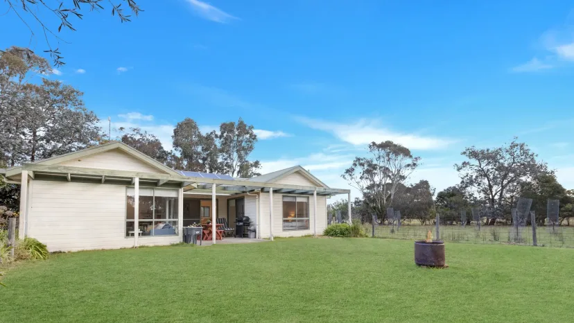 Woongara Cottage seen across the paddock, with the farm gate in the foreground