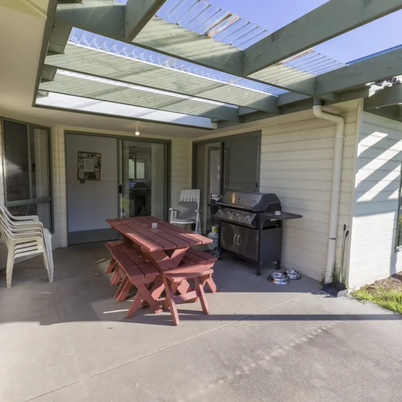 Covered outdoor area at Eagle Point Cottages with a picnic table and barbecue