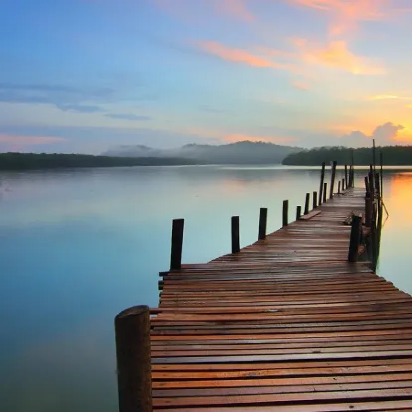 An old timber jetty reaching into the lake at dawn