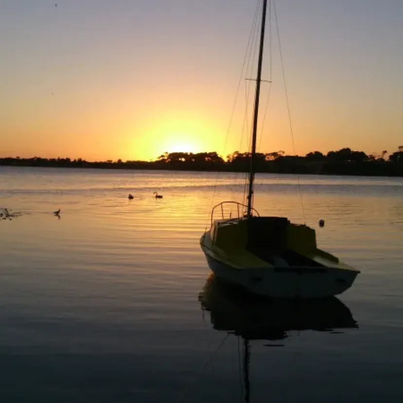 A yacht moored on the lake silhouetted against the sunset